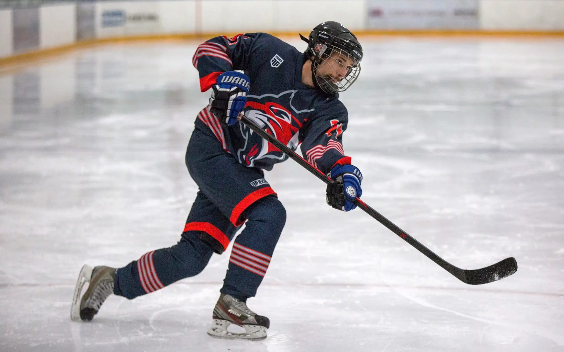 Hockey player in a navy custom jersey skating hard on fresh ice