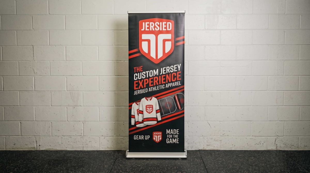 Black and red Jersied pull-up banner against a brick wall